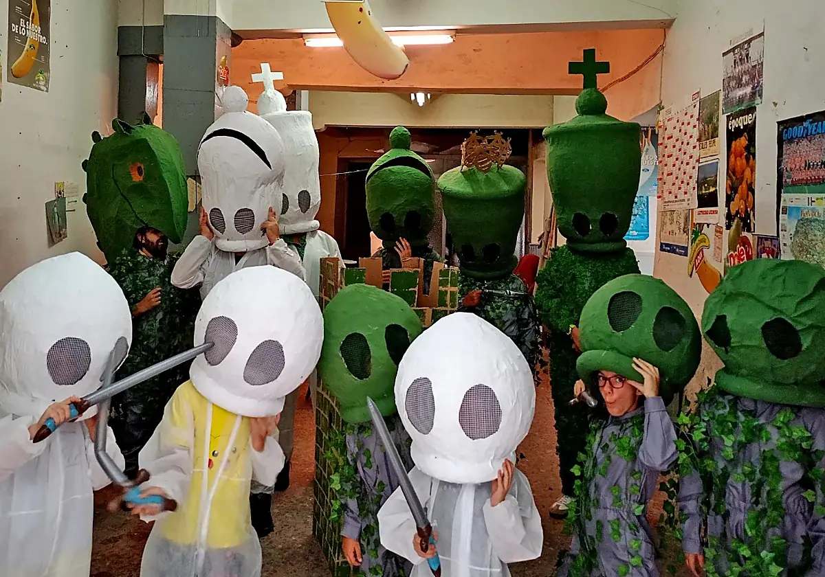 Participantes del ajedrez viviente con piezas blancas y verdes inspiradas en los Hombres de Musgo